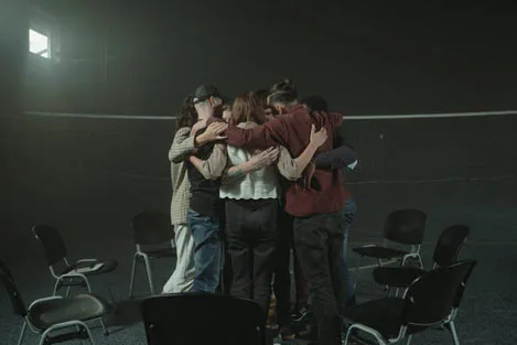 People in group therapy hugging each other.